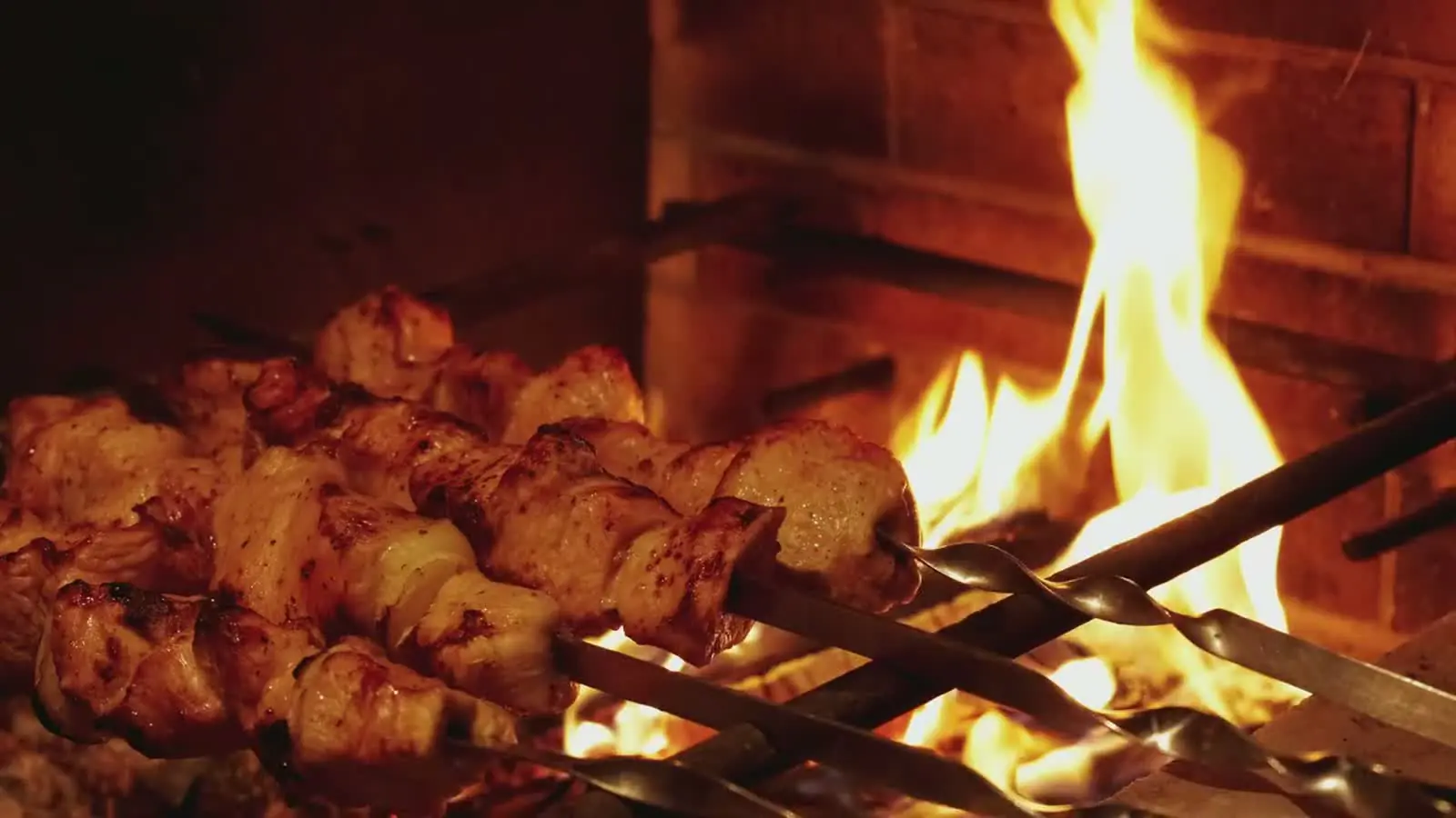 Chicken tikka skewers grilling over an open fire